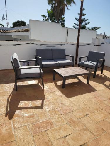 a patio with two chairs and a couch and a table at Sweet Family House in Cala d´Or
