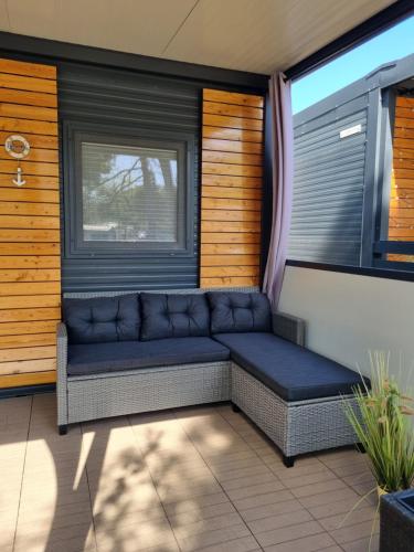 a couch sitting on a balcony with a window at Sand & Relax Privlaka - Mobile home "Lavanda" in Privlaka