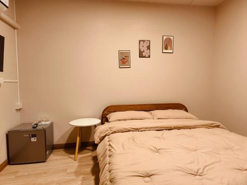 a bedroom with two beds and a small table at หลับดี เขาใหญ่ รีสอร์ท in Ban Wa Kachieo
