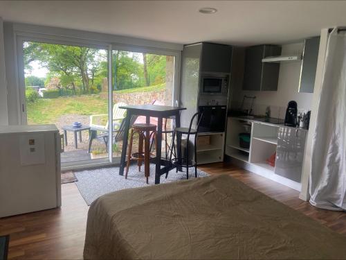 une chambre avec un lit et une cuisine avec une table dans l'établissement Studio à la campagne, à Cordemais