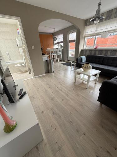 a living room with a couch and a table at Apartment at the Beach in Noordwijk aan Zee