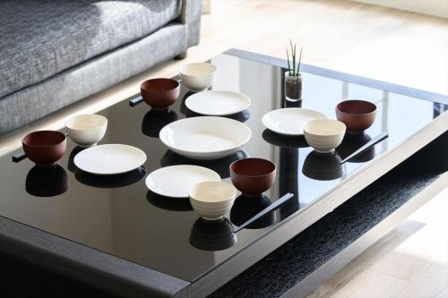 a coffee table with bowls and cups on top of it at LIT広島駅前 広島駅から徒歩5分 全室リバービューでベッドはairweaveを採用 Spacious rooms with river views all to yourself Supported in Ōsukachō