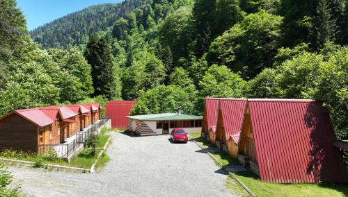 una fila di capanne con un'auto parcheggiata in un parcheggio di Kackar Resort Hotel ad Ayder Yaylasi