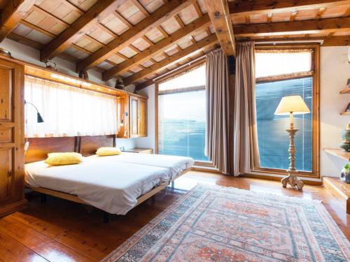a bedroom with a bed and large windows at Cal Tomas in Castellet