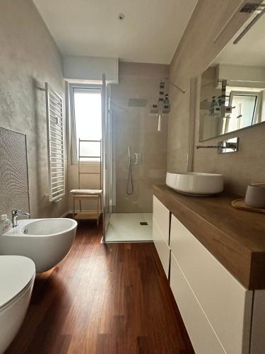 a bathroom with a white tub and a sink at Limone Al Mare in Albenga