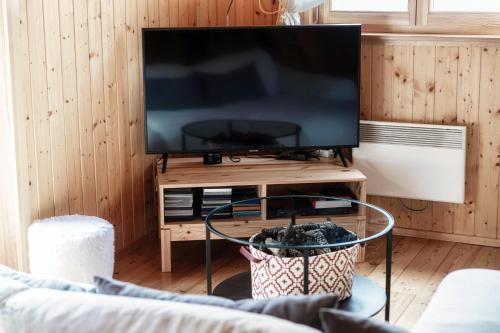 a living room with a flat screen tv on a table at Romantic Chalet in the Leventina Mountains by Quokka 360 - Romantic Chalet in Faido