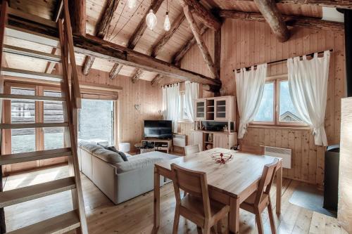 a living room with a table and a couch at Romantic Chalet in the Leventina Mountains by Quokka 360 - Romantic Chalet in Faido