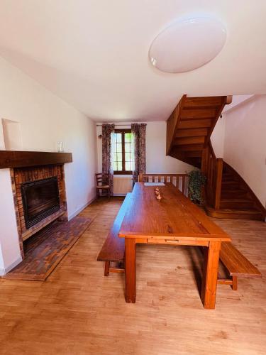 Cette chambre comprend une grande table en bois et une cheminée. dans l'établissement Maison de Campagne à 2km du centre de SARLAT, à Sarlat-la-Canéda