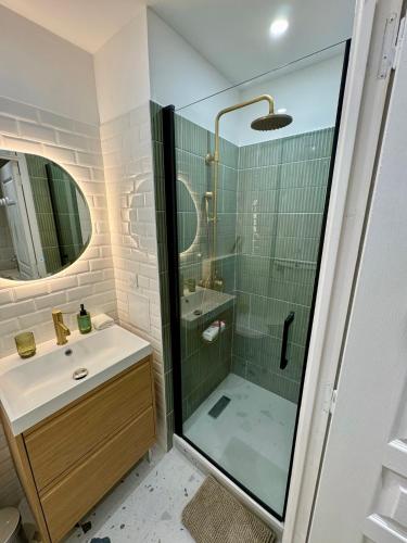 une salle de bain avec une douche en verre et un lavabo dans l'établissement Séjour magique au cœur de Paris, à Paris