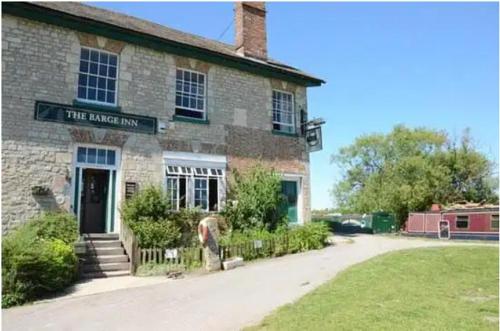 a brick building with a sign that reads the harlem inn at The Barge Inn, Honeystreet in Alton Barnes