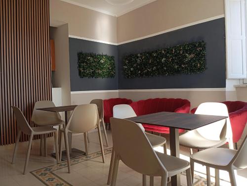 a restaurant with two tables and chairs and a red couch at B&B il Palazzo Cirella in Cirella