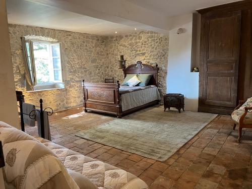 a bedroom with a bed in the corner of a room at Charmante maison de famille rustique à la campagne in Groslée