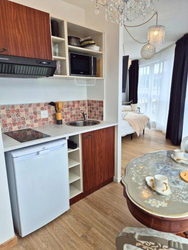 - une cuisine avec un évier et une table dans une chambre dans l'établissement Céleste Premium Suite Amazing View Train Station, à Lourdes