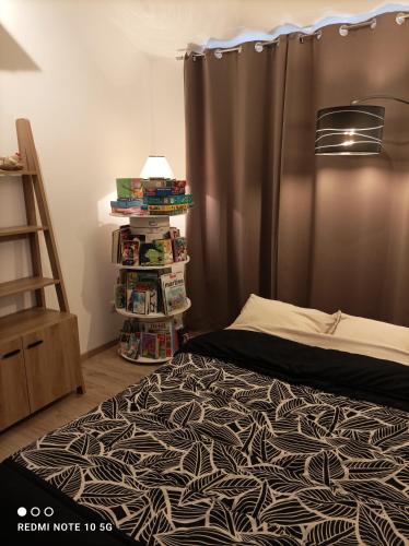 - une chambre avec un lit et une étagère avec des livres dans l'établissement Gîte Chez Mamema, à Marlenheim