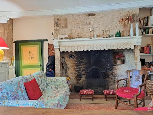 a living room with a couch and a fireplace at "Les Tournesols" piscine, campagne, idéal familles in Sauveterre