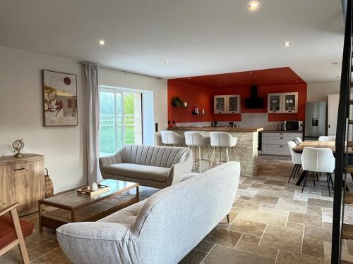 a living room with a couch and a kitchen at Gîte 4 de l être aux Rues in Chailloué
