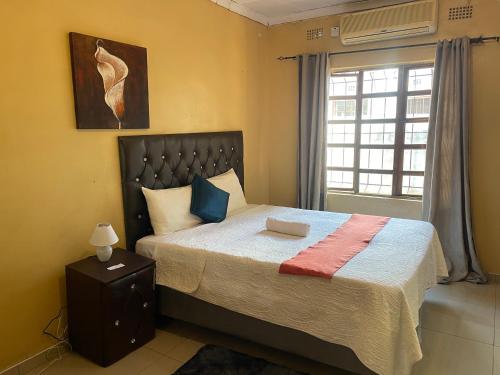 een slaapkamer met een groot bed en een raam bij Ntshe River Lodge in Francistown