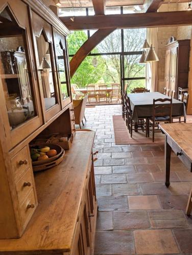 a kitchen with a dining room with a table at "Les Tournesols" piscine, campagne, idéal familles in Sauveterre