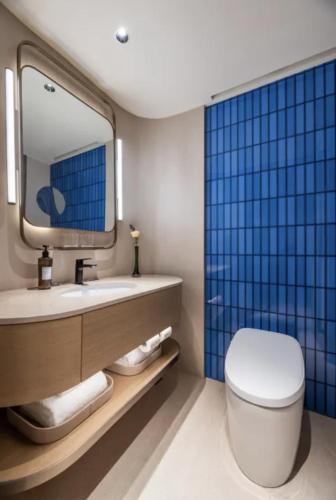 a bathroom with a toilet and a sink and a mirror at Crystal Orange Hotel Shanghai Chongming Nanmen in Shanghai