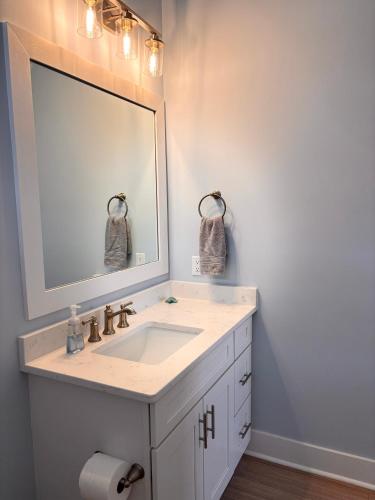 a bathroom with a sink and a large mirror at The Kure House in Kure Beach