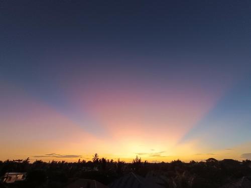 a sky with the sun setting in the horizon at Mgongo tree house in Jambiani