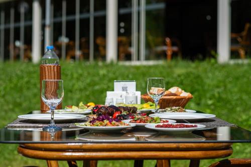 un tavolo con piatti di cibo e bicchieri di vino di Kackar Resort Hotel ad Ayder Yaylasi