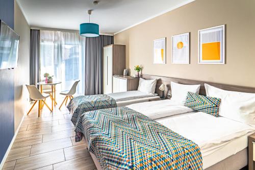 a hotel room with two beds and a table at Kamienica Mielno in Mielno
