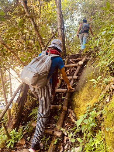 a man climbing up a set of stairs on a trail at maison Rose & Jardinier eco homestay in Sa Pa