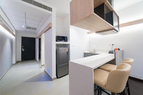 a kitchen with a counter and some chairs in it at Hotel Deccan Serai Grande, Gachibowli, Hyderabad in Hyderabad