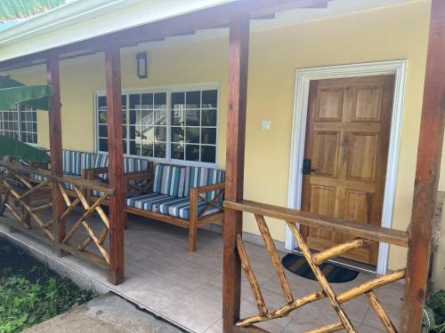 a screened in porch with a bench and a door at Yoga Dreams Negril in Negril