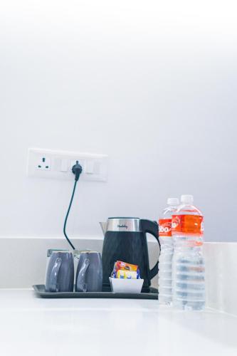a kitchen counter with a coffee maker and a bottle of water at Hotel Deccan Serai Grande, Gachibowli, Hyderabad in Hyderabad