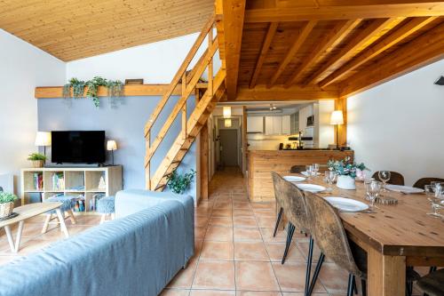 une salle à manger avec un canapé bleu et une table dans l'établissement La maison d’Anthelmette, à Valloire