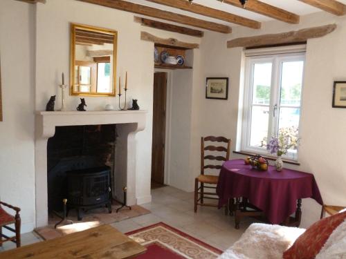 un salon avec une table et une cheminée dans l'établissement Old French Country Cottage for 2 nature lovers paradise, à Châteaumeillant