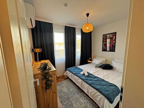 Un dormitorio pequeño con una cama y una ventana. en AURA BEACH apartment, en Burgas