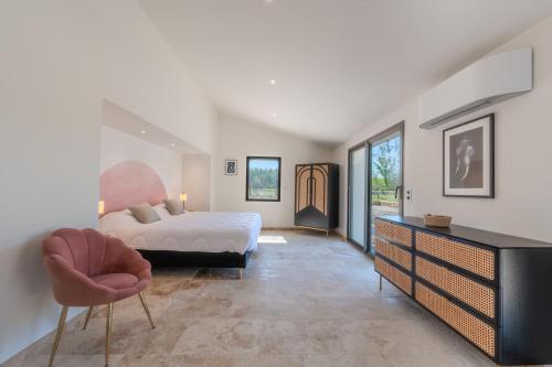 - une chambre avec un lit, une chaise et une commode dans l'établissement Mas de l' écluse, à Maussane-les-Alpilles