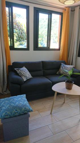 a living room with a couch and a table at Hébergement-Joli T3-70m2-Terrasse-Jardin in LʼEntre-Deux