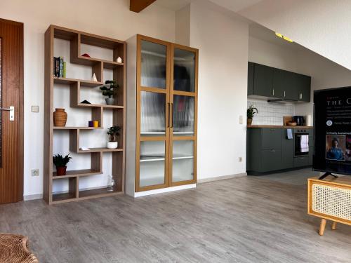 a living room with green cabinets and a kitchen at City-View Studio with Balcony, Dessau in Dessau
