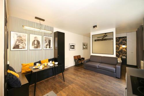 un salon avec un canapé et une table dans l'établissement Appartement Paris 13 universite - 4P RDC, à Paris
