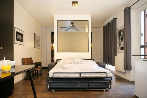 une chambre avec un lit avec un ventilateur de plafond dans l'établissement Appartement Paris 13 universite - 4P RDC, à Paris