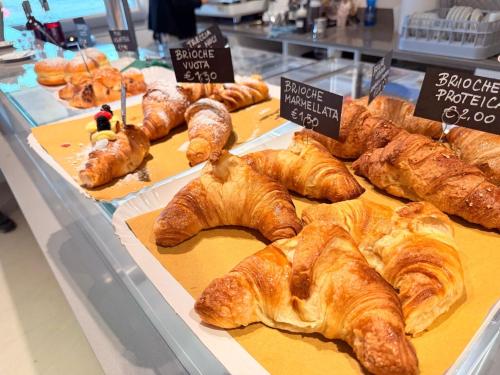 a bakery with croissants and other pastries on display at B-Village Bar and Rooms in San Martino al Tagliamento