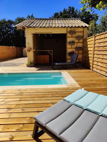 - une piscine avec banc à côté d'un bâtiment dans l'établissement Superbe villa en Provence, piscine et pétanque, à Rognonas