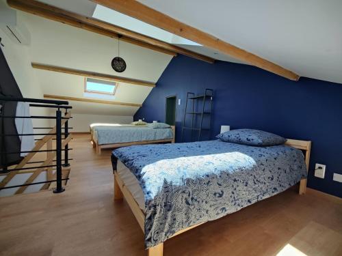 une chambre avec deux lits et un mur bleu dans l'établissement Superbe villa en Provence, piscine et pétanque, à Rognonas