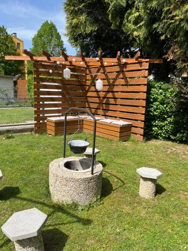 a bird bath in a yard with two benches at Réka Apartmanház in Bük
