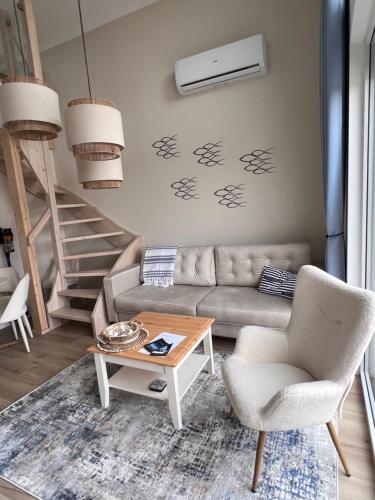 a living room with a couch and a table at Casa Kashubia - Nowoczesny dom wakacyjny nad jeziorem - Cisza natura i komfort in Brzeźno Szlacheckie