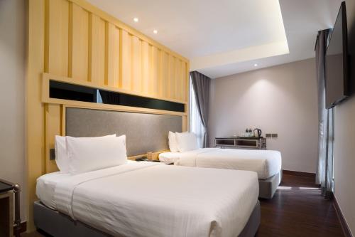two beds in a hotel room with two beds at T2 The Portal Sukhumvit in Bangkok