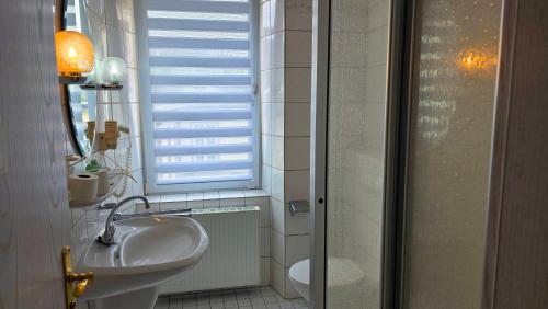 a bathroom with a sink and a mirror and a window at Eifeler Hof - Ihr Restaurant für Genussmomente in Kyllburg in Kyllburg
