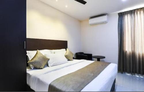 a bedroom with a large bed and a window at Akshara Innotel in Visakhapatnam