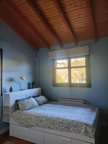 una cama en un dormitorio con ventana en 3 habitaciones hasta para 6 personas en chalet con jardín a 15 minutos de Vitoria y 25 de Bilbao, en Izarra