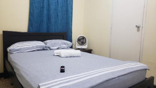 a bed with two towels and a remote control on it at Mom's House Granada in Cali