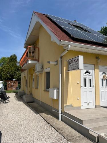 a building with solar panels on the side of it at Réka Apartmanház in Bük